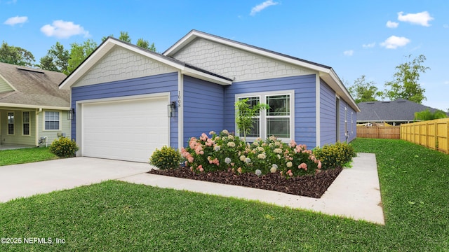 view of front of house featuring a garage, concrete driveway, a front lawn, and fence