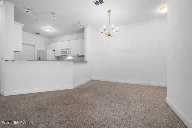 kitchen with carpet floors, a notable chandelier, visible vents, white appliances, and baseboards