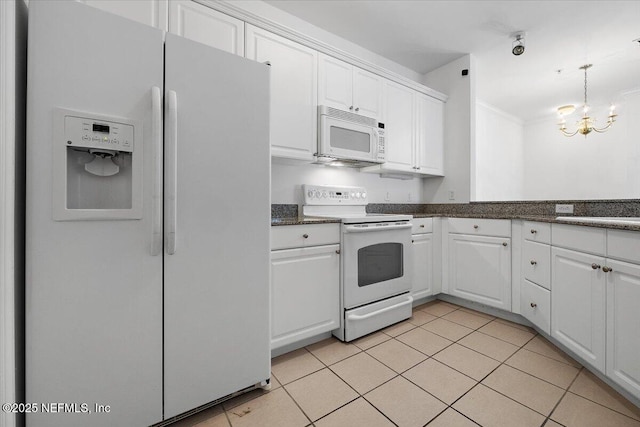 kitchen featuring dark countertops, white appliances, white cabinets, and light tile patterned flooring