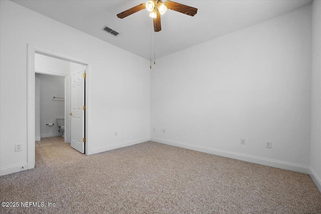 unfurnished bedroom with carpet floors, visible vents, a ceiling fan, ensuite bath, and baseboards