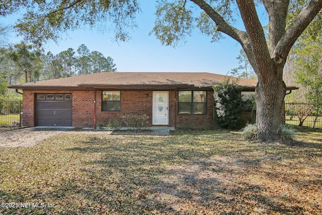 ranch-style house featuring a garage, brick siding, and fence