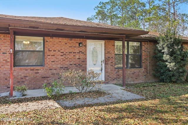 property entrance featuring brick siding