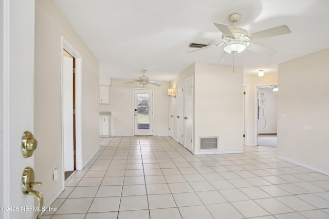 spare room with baseboards, visible vents, a ceiling fan, and light tile patterned flooring