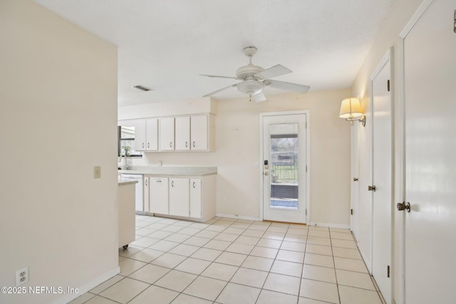 kitchen featuring light tile patterned floors, baseboards, white cabinets, ceiling fan, and light countertops