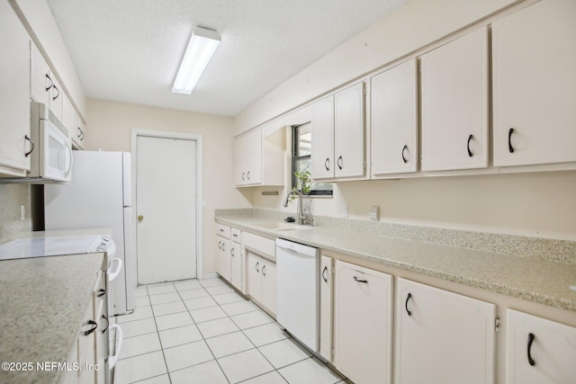 kitchen with white appliances, light tile patterned floors, white cabinets, light countertops, and a sink