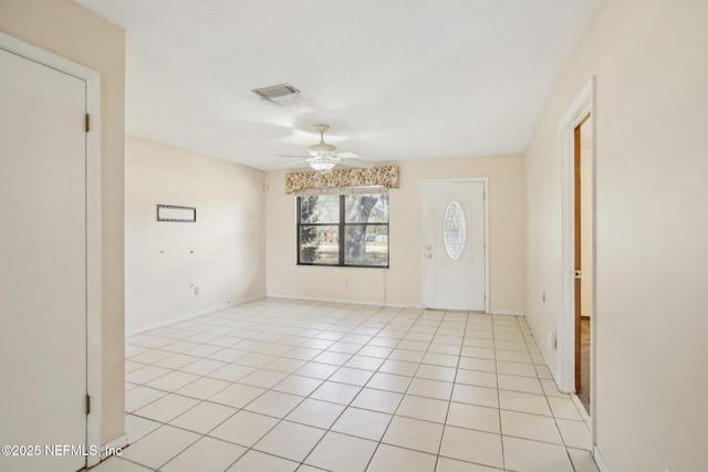 unfurnished room featuring a ceiling fan, light tile patterned flooring, visible vents, and baseboards