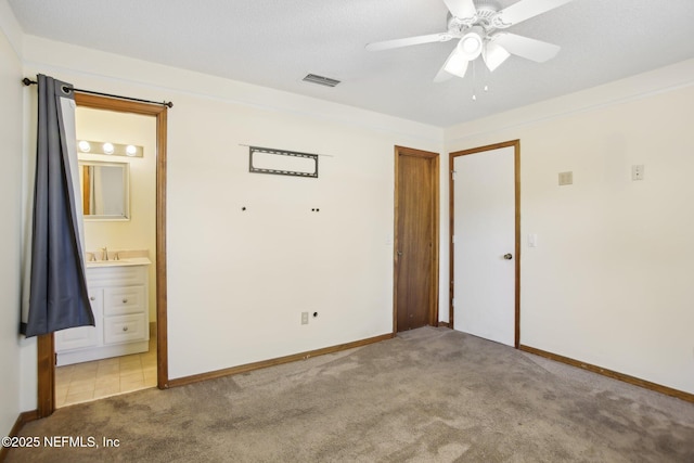 unfurnished bedroom featuring visible vents, connected bathroom, light carpet, and baseboards