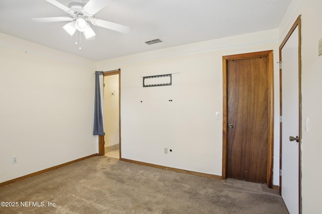 unfurnished bedroom featuring baseboards, visible vents, a textured ceiling, and carpet flooring