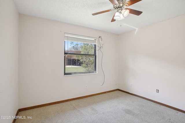 spare room featuring carpet floors, a textured ceiling, baseboards, and a ceiling fan