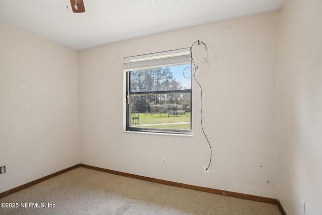 unfurnished room featuring carpet floors, ceiling fan, a textured ceiling, and baseboards