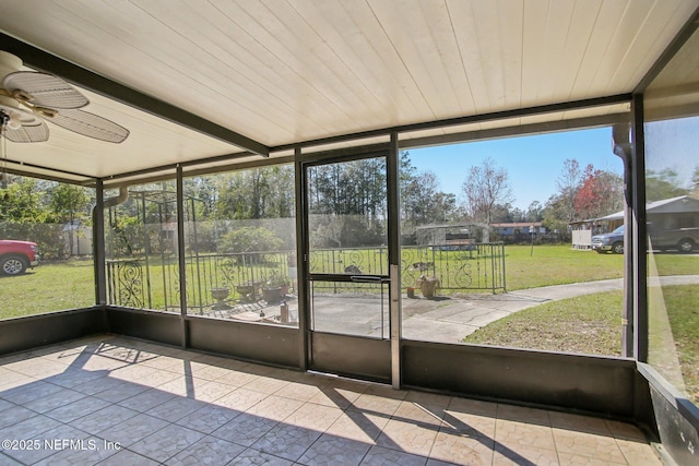 unfurnished sunroom featuring a ceiling fan