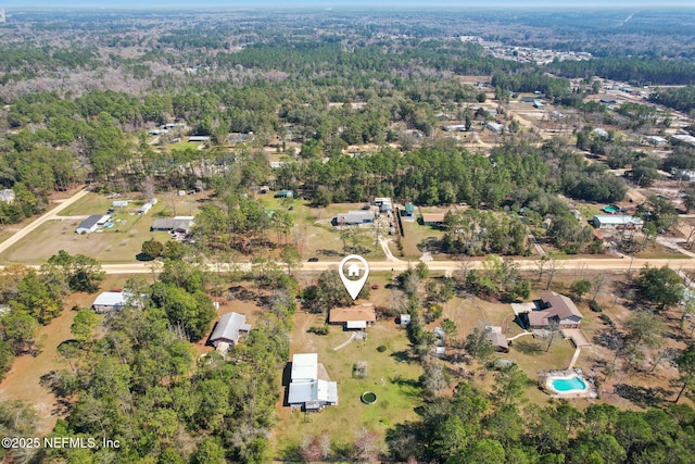 drone / aerial view with a wooded view