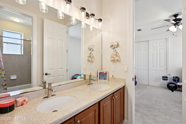 full bathroom with ceiling fan, double vanity, a sink, and visible vents