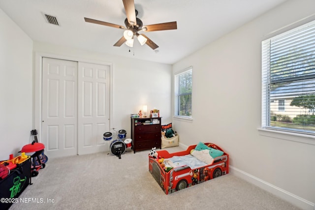 bedroom featuring a ceiling fan, visible vents, baseboards, a closet, and carpet