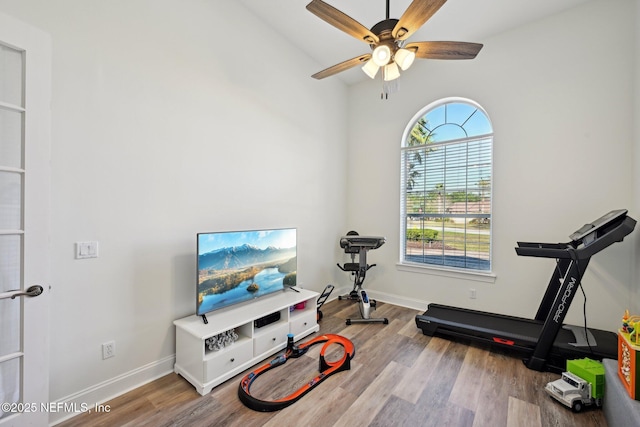 exercise area featuring ceiling fan, baseboards, and wood finished floors