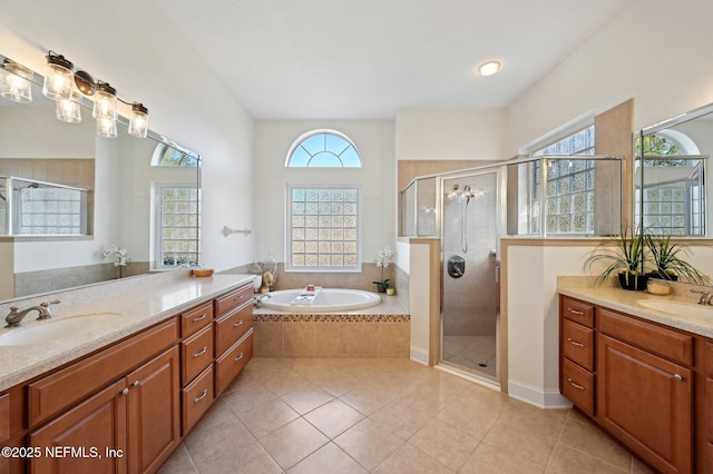 full bath with a bath, tile patterned flooring, a shower stall, and a sink