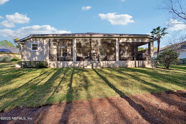 rear view of property with a sunroom and a yard