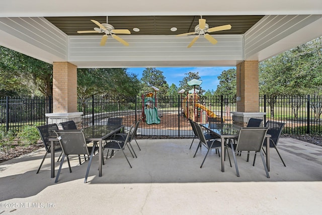 view of patio / terrace featuring outdoor dining area, playground community, and fence