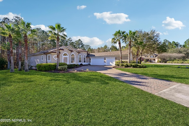 243 Stonewell Dr, Saint Johns, FL 32259 - mediterranean / spanish home with decorative driveway, a garage, a front lawn, and stucco siding