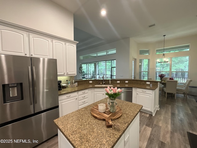 243 Stonewell Dr, Saint Johns, FL 32259 - kitchen featuring stainless steel appliances, a peninsula, white cabinetry, and dark stone counters