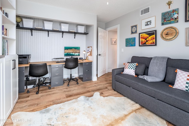 home office with light wood finished floors and visible vents