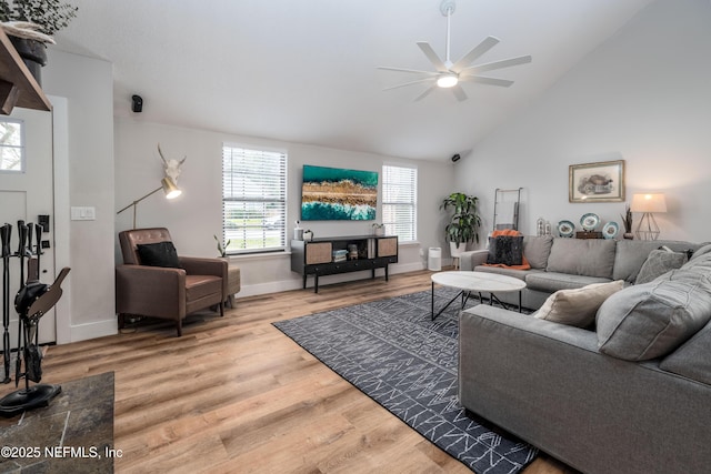 living room featuring high vaulted ceiling, a ceiling fan, baseboards, and wood finished floors