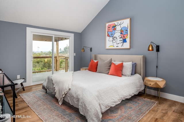 bedroom featuring access to outside, vaulted ceiling, baseboards, and wood finished floors