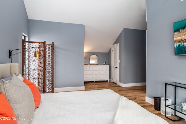 bedroom with light wood-style flooring and baseboards