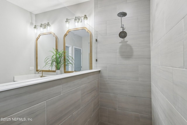 full bathroom featuring a tile shower and vanity