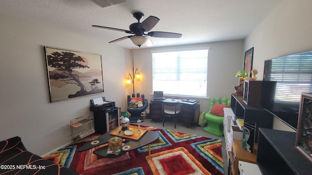 carpeted office space with visible vents, a ceiling fan, and a textured ceiling