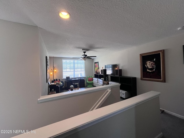 interior space with a textured ceiling, carpet, visible vents, and a ceiling fan