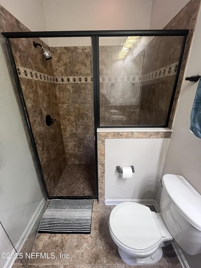 bathroom with tile patterned flooring, a shower stall, and toilet