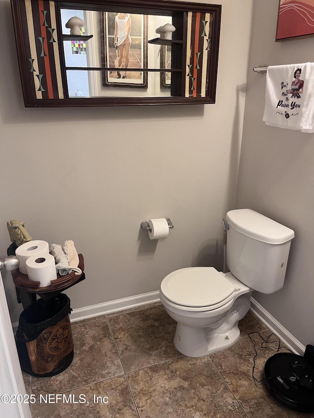 bathroom featuring toilet and baseboards