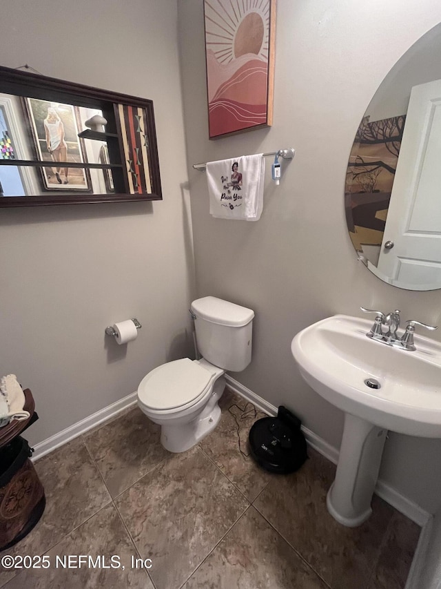 bathroom with toilet and baseboards