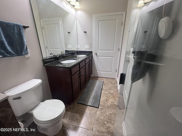 bathroom with double vanity, a sink, toilet, and walk in shower