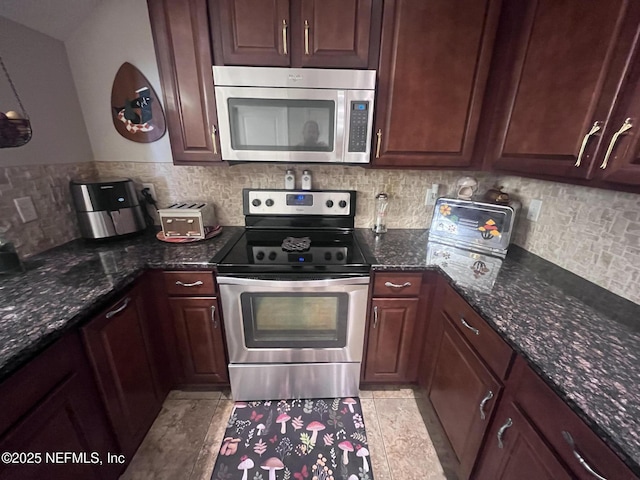 kitchen featuring appliances with stainless steel finishes, dark stone countertops, and decorative backsplash