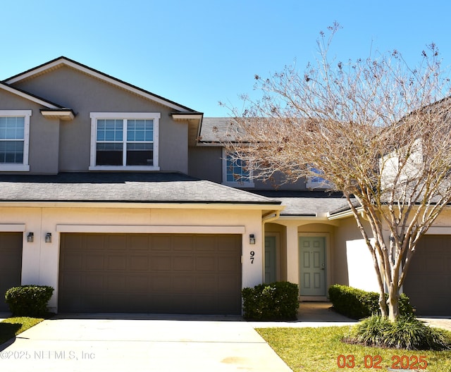 view of property featuring roof with shingles and stucco siding