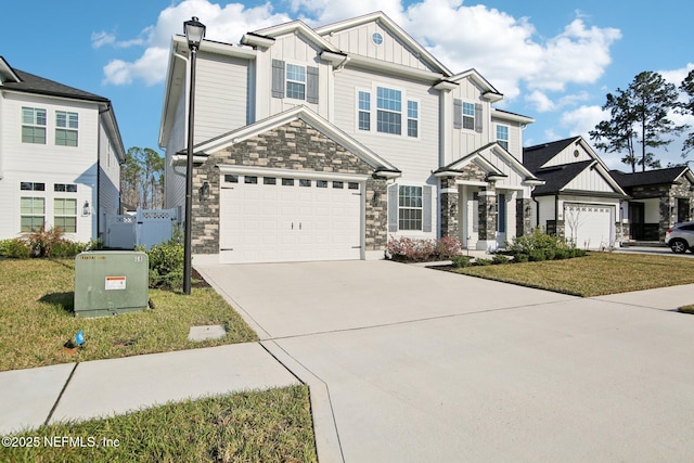 craftsman house with driveway, stone siding, a front lawn, and board and batten siding