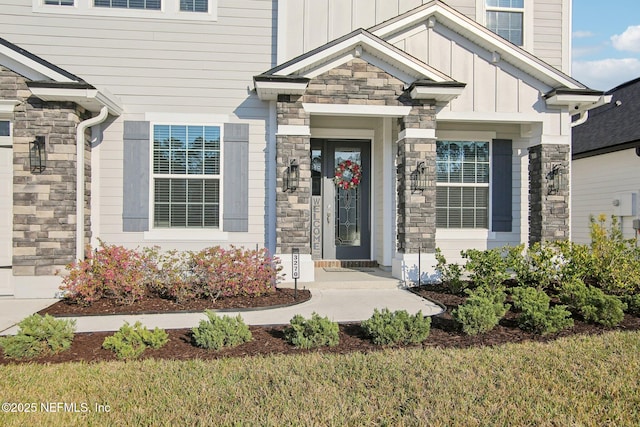 property entrance featuring board and batten siding and stone siding