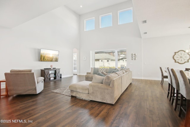 living area with plenty of natural light, visible vents, and dark wood-style flooring