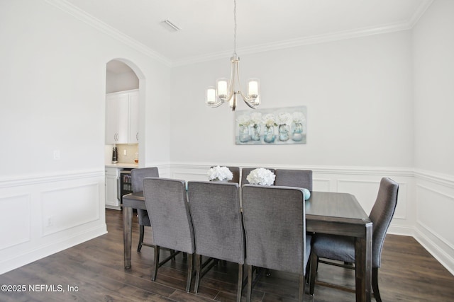 dining space featuring dark wood finished floors, visible vents, and crown molding