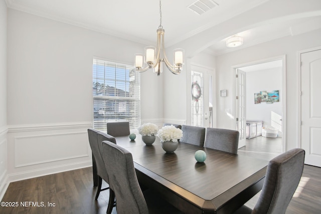 dining space featuring a chandelier, visible vents, ornamental molding, wainscoting, and dark wood-style floors