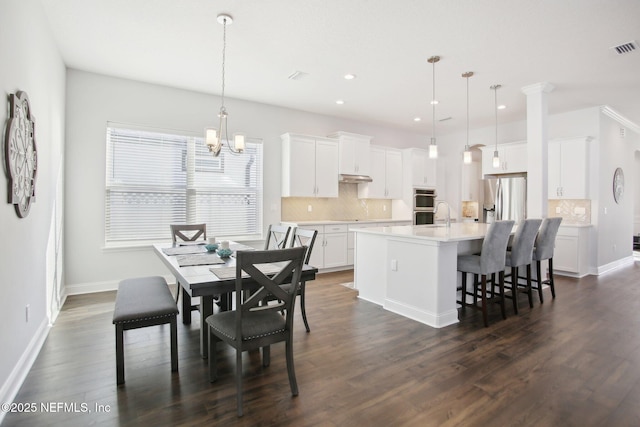 dining area with dark wood-style flooring, a notable chandelier, recessed lighting, visible vents, and baseboards