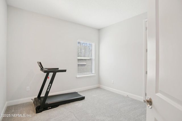 exercise area featuring carpet floors and baseboards