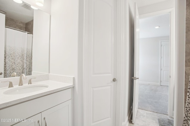 bathroom with curtained shower, visible vents, and vanity