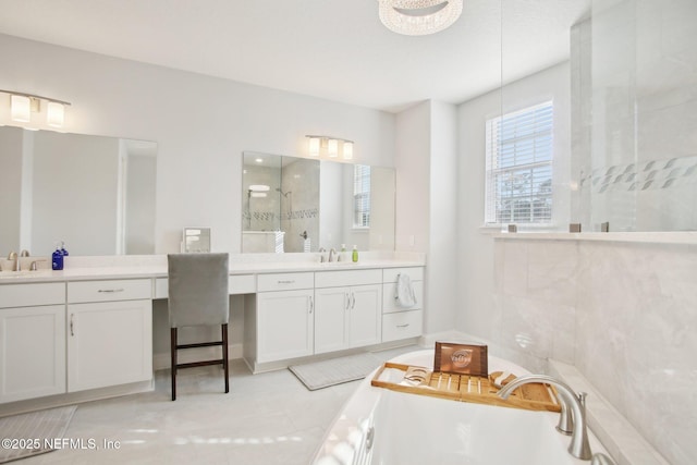 full bathroom featuring a freestanding tub, two vanities, walk in shower, and a sink