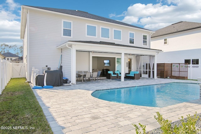 back of property with a fenced in pool, a patio, a fenced backyard, a gate, and outdoor lounge area