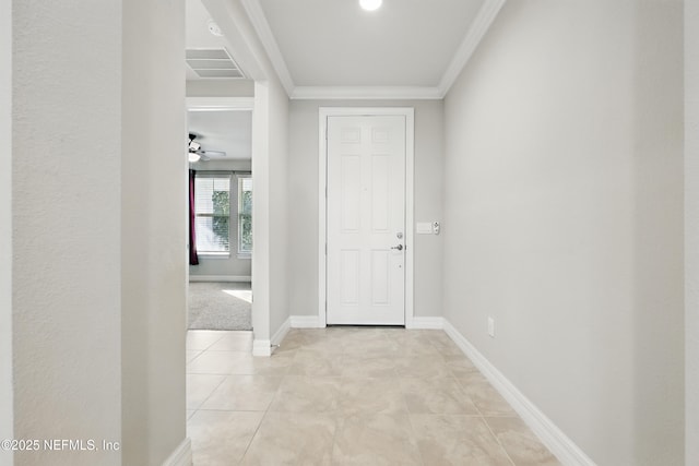 foyer featuring light tile patterned floors, ceiling fan, visible vents, baseboards, and ornamental molding