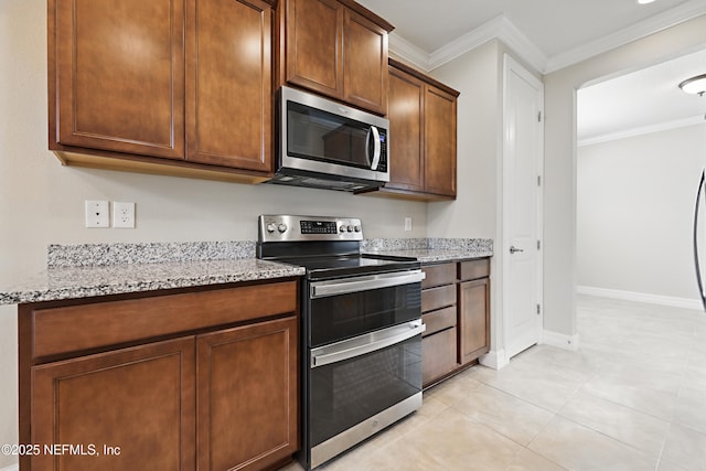 kitchen with baseboards, appliances with stainless steel finishes, light stone counters, and ornamental molding