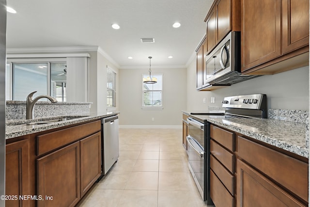 kitchen featuring light tile patterned floors, appliances with stainless steel finishes, ornamental molding, light stone countertops, and a sink